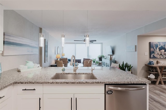 400 Island Way Unit 1709, Clearwater Beach, FL 33767 - kitchen featuring stainless steel dishwasher, open floor plan, light wood-style floors, and light stone countertops