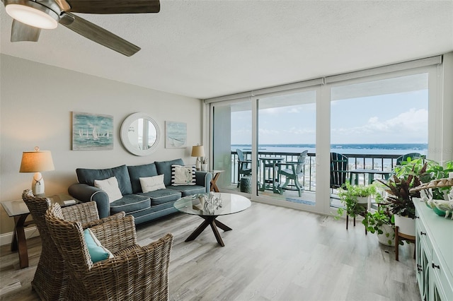 400 Island Way Unit 1709, Clearwater Beach, FL 33767 - living area featuring wood finished floors, plenty of natural light, a water view, a textured ceiling, and ceiling fan
