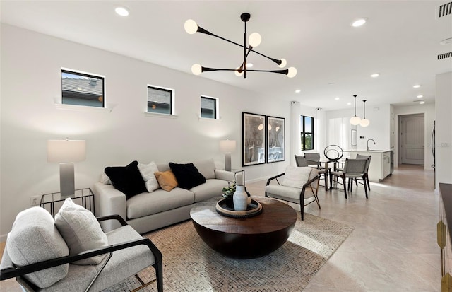 living room featuring a chandelier, recessed lighting, and baseboards
