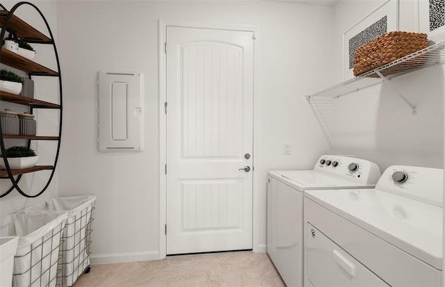 clothes washing area with washing machine and clothes dryer, baseboards, electric panel, and light tile patterned floors