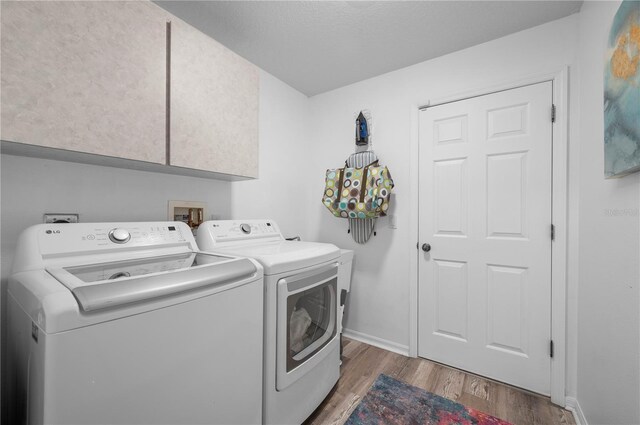 5193 Boyle Ter, Port Charlotte, FL 33981 - laundry area featuring washing machine and dryer, wood finished floors, cabinet space, and baseboards