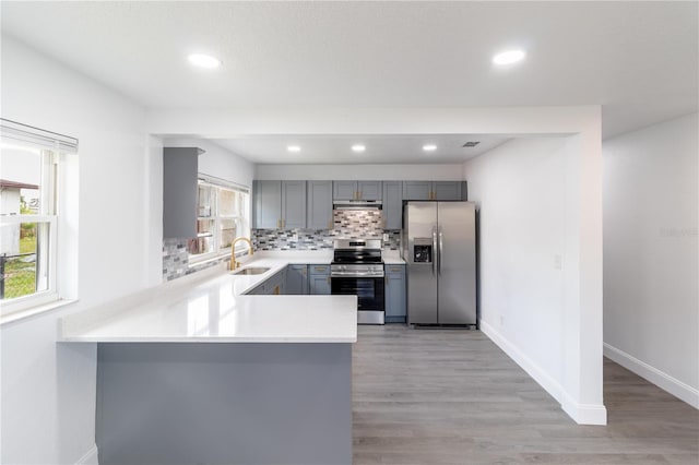 5210 S 80th St, Tampa, FL 33619 - kitchen featuring stainless steel appliances, gray cabinetry, a sink, light countertops, and decorative backsplash