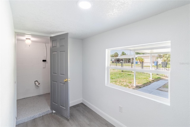5210 S 80th St, Tampa, FL 33619 - unfurnished bedroom featuring a textured ceiling, baseboards, and wood finished floors