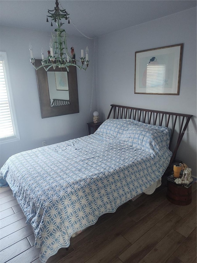 bedroom featuring an inviting chandelier and wood-type flooring
