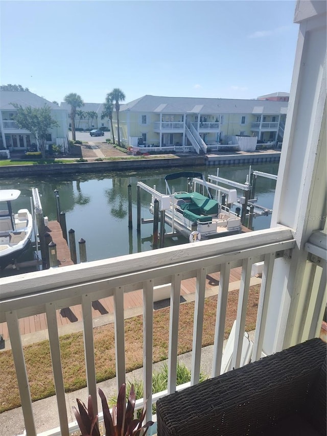 balcony featuring a water view, a dock, and a residential view