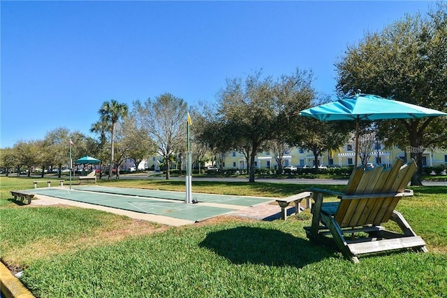 surrounding community featuring shuffleboard and a lawn