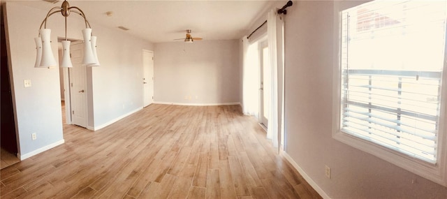 unfurnished room with light wood finished floors, baseboards, and a ceiling fan