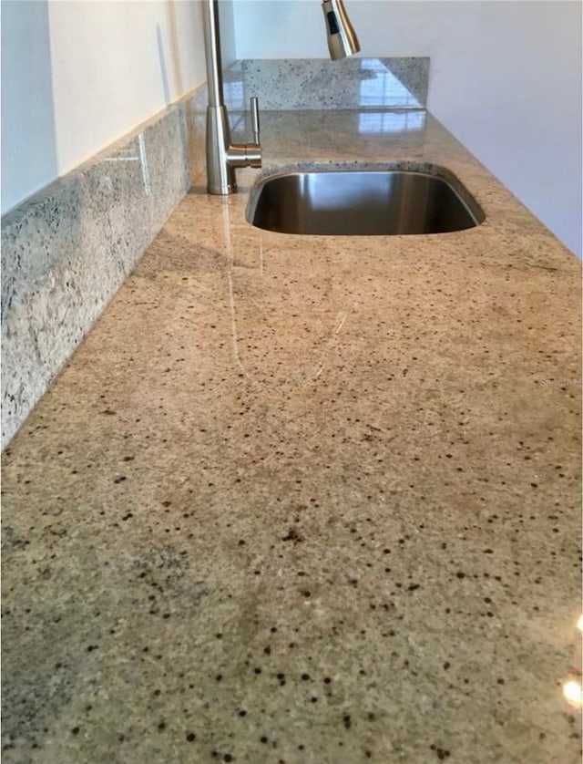 kitchen view of a sink and light stone countertops
