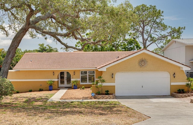 315 Ridge Rd, Palm Harbor, FL 34683 - view of front of home featuring french doors, an attached garage, stucco siding, driveway, and a tile roof