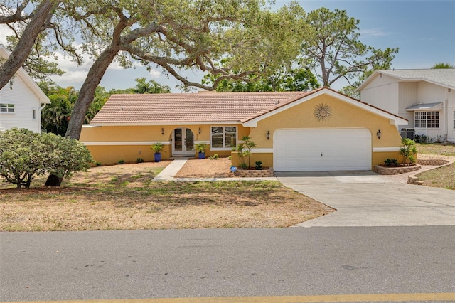 315 Ridge Rd, Palm Harbor, FL 34683 - ranch-style home featuring french doors, stucco siding, a garage, concrete driveway, and a tiled roof