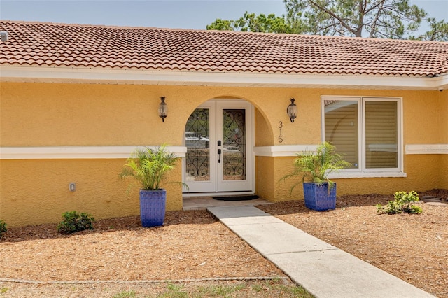 315 Ridge Rd, Palm Harbor, FL 34683 - property entrance featuring stucco siding, a tile roof, and french doors
