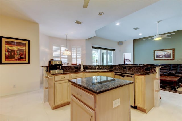 kitchen featuring a sink, a center island, stainless steel dishwasher, dark stone counters, and recessed lighting