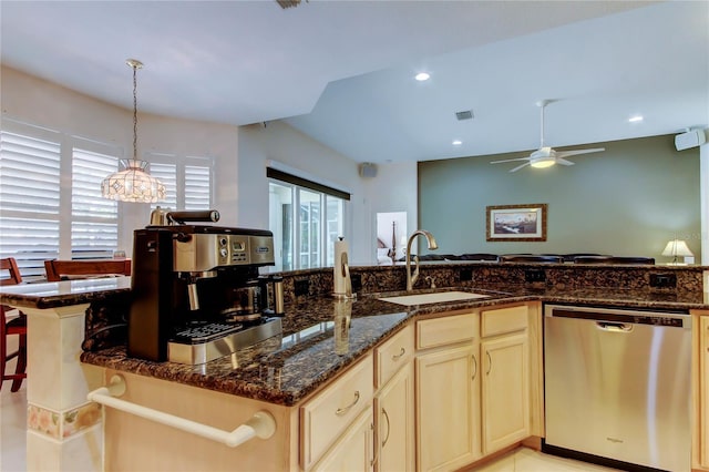kitchen featuring dishwasher, a sink, ceiling fan, dark stone counters, and decorative light fixtures
