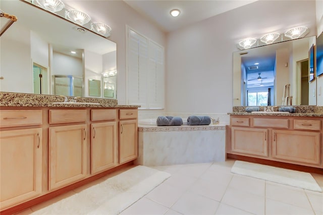 full bathroom featuring a shower stall, a bath, two vanities, and tile patterned flooring