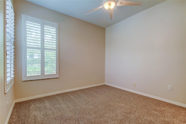 carpeted spare room featuring ceiling fan and baseboards