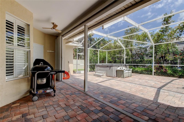 view of patio / terrace with a hot tub, glass enclosure, a ceiling fan, and grilling area
