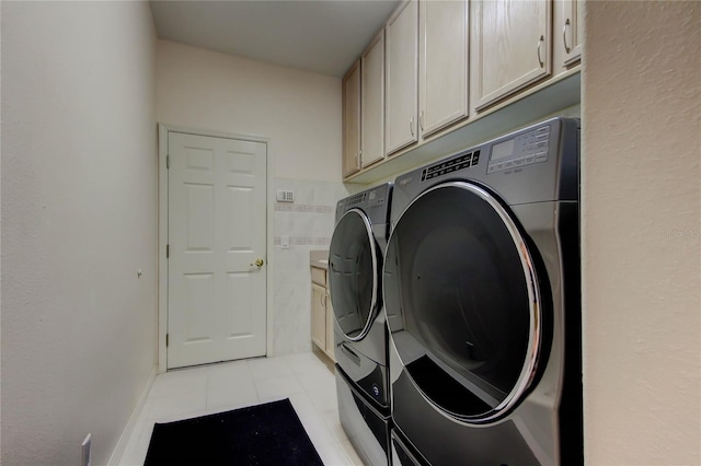 2220 Elizabeth Way, Dunedin, FL 34698 - laundry room featuring washing machine and clothes dryer, cabinet space, and light tile patterned flooring