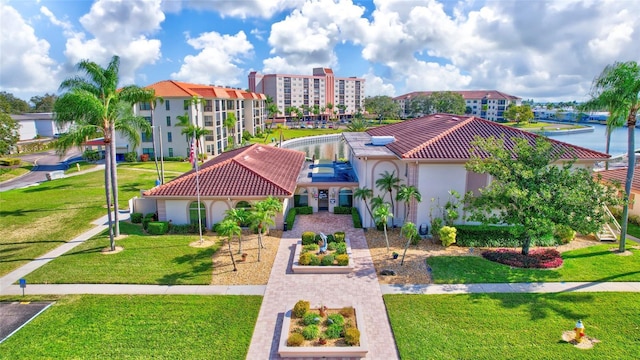 view of front of property featuring a tiled roof, a front lawn, and stucco siding