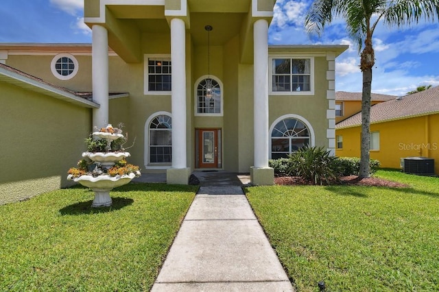 27012 Sea Breeze Way, Wesley Chapel, FL 33544 - view of front of home featuring stucco siding, a front yard, and central AC