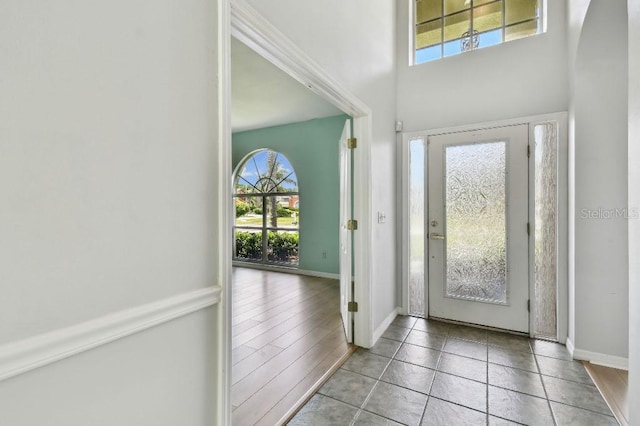 27012 Sea Breeze Way, Wesley Chapel, FL 33544 - tiled foyer entrance featuring plenty of natural light, baseboards, arched walkways, and a high ceiling