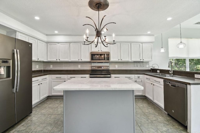 27012 Sea Breeze Way, Wesley Chapel, FL 33544 - kitchen with stainless steel appliances, a sink, light tile patterned floors, a chandelier, and recessed lighting