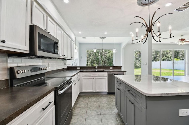 27012 Sea Breeze Way, Wesley Chapel, FL 33544 - kitchen featuring appliances with stainless steel finishes, gray cabinetry, a sink, backsplash, and recessed lighting