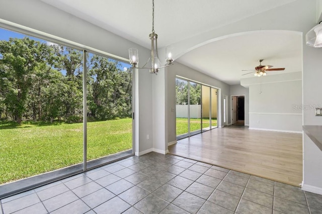 27012 Sea Breeze Way, Wesley Chapel, FL 33544 - unfurnished dining area with ceiling fan, tile patterned flooring, baseboards, a chandelier, and arched walkways