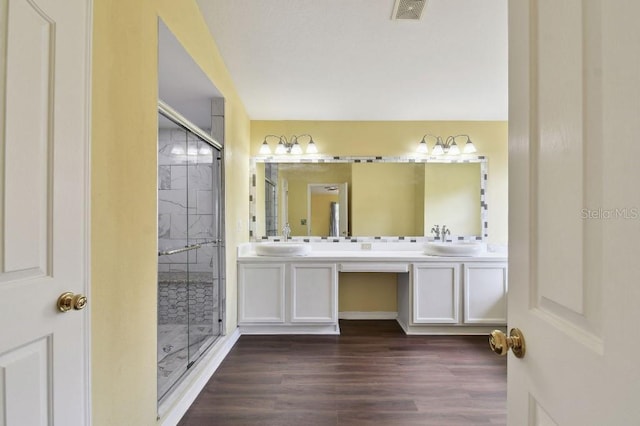 27012 Sea Breeze Way, Wesley Chapel, FL 33544 - bathroom with double vanity, a stall shower, and wood finished floors