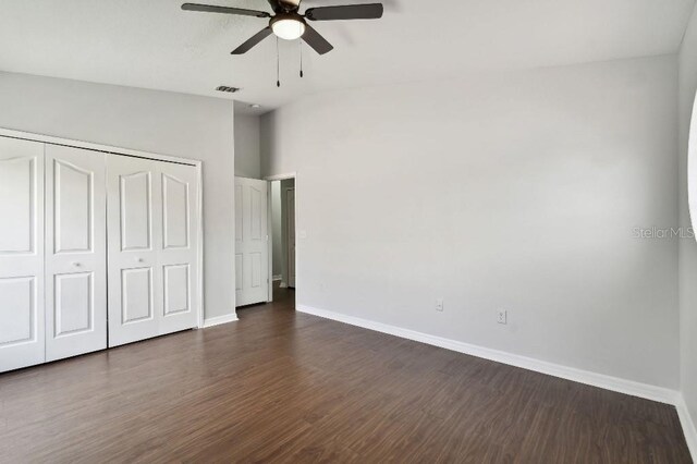 27012 Sea Breeze Way, Wesley Chapel, FL 33544 - unfurnished bedroom with baseboards, dark wood-type flooring, a closet, and a ceiling fan