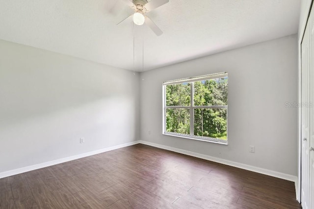 27012 Sea Breeze Way, Wesley Chapel, FL 33544 - spare room with dark wood-type flooring, a ceiling fan, and baseboards