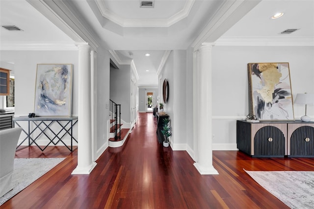 entryway featuring ornate columns, wood finished floors, stairs, crown molding, and baseboards
