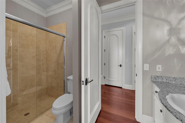 bathroom featuring wood finished floors, a stall shower, ornamental molding, toilet, and vanity