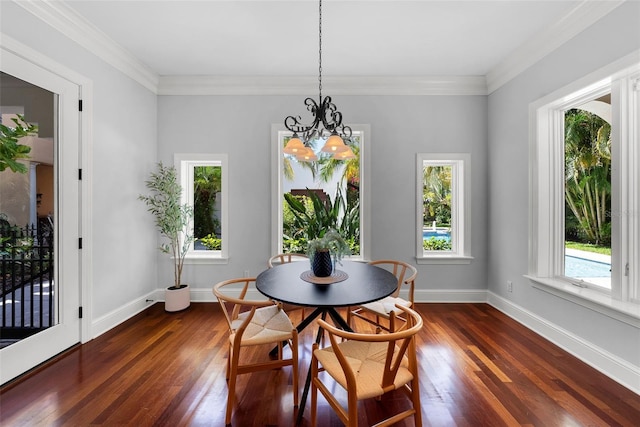 dining room with dark wood finished floors, a chandelier, baseboards, and crown molding