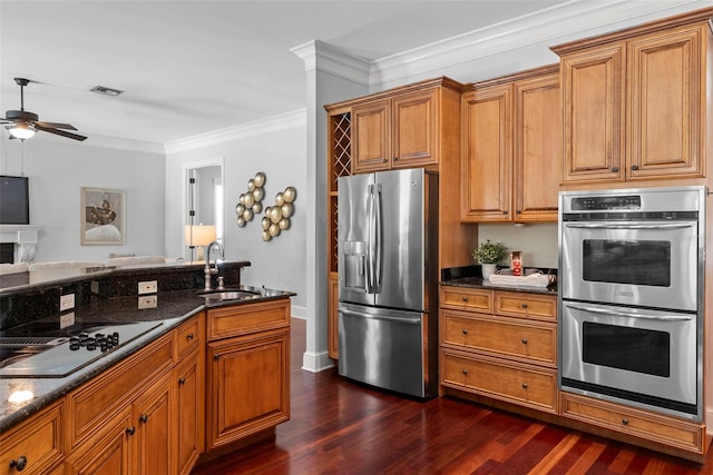 kitchen featuring appliances with stainless steel finishes, a sink, ceiling fan, dark wood-style floors, and crown molding