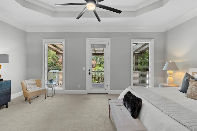 bedroom with a tray ceiling, access to outside, carpet floors, multiple windows, and crown molding