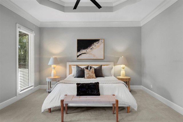 bedroom featuring carpet floors, ornamental molding, a raised ceiling, ceiling fan, and baseboards