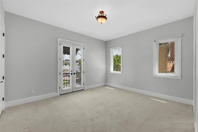 unfurnished room with baseboards, carpet floors, and french doors