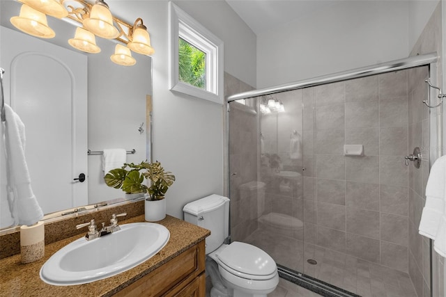 bathroom with a shower stall, vanity, and toilet