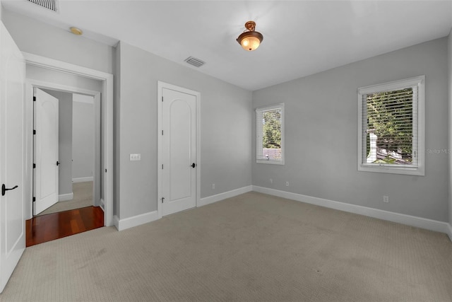 unfurnished bedroom with light carpet and baseboards