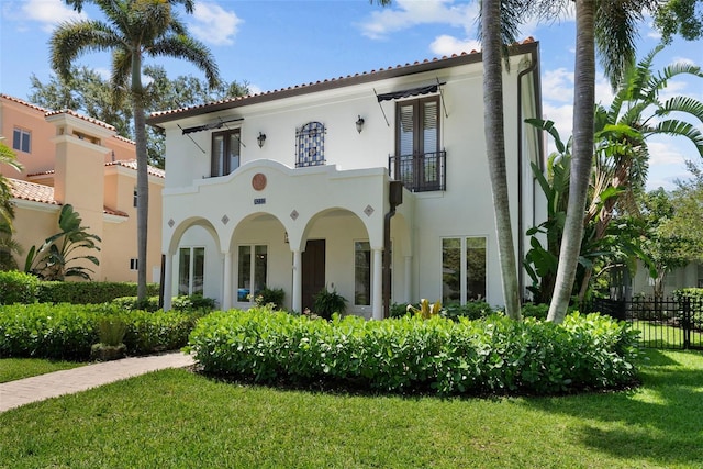 rear view of house with a balcony and stucco siding