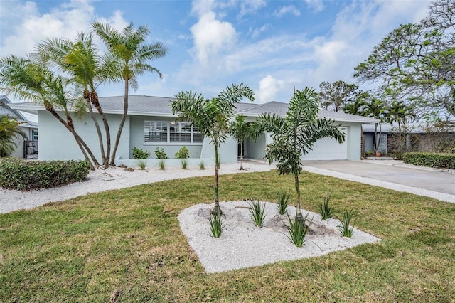7092 S Shore Dr S, Saint Petersburg, FL 33707 - view of front of home featuring an attached garage, stucco siding, concrete driveway, and a front yard