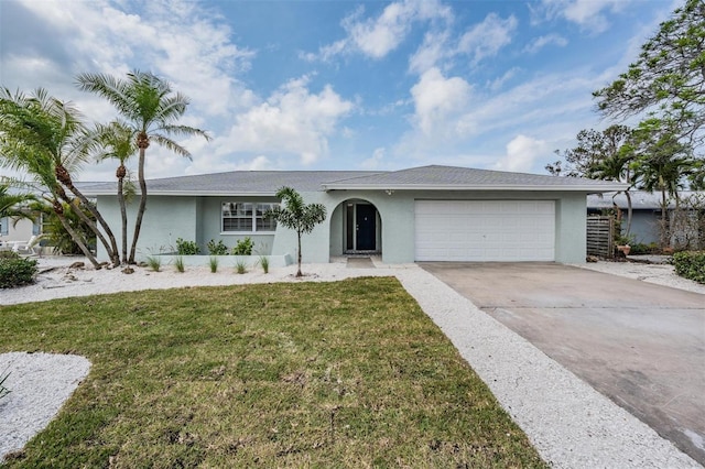 7092 S Shore Dr S, Saint Petersburg, FL 33707 - ranch-style home featuring stucco siding, a garage, driveway, and a front lawn