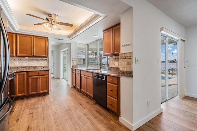7092 S Shore Dr S, Saint Petersburg, FL 33707 - kitchen with dishwashing machine, a sink, a tray ceiling, brown cabinetry, and ceiling fan