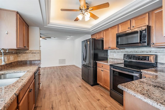7092 S Shore Dr S, Saint Petersburg, FL 33707 - kitchen with stainless steel appliances, a ceiling fan, a raised ceiling, backsplash, and light stone countertops