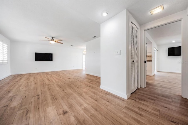 7092 S Shore Dr S, Saint Petersburg, FL 33707 - unfurnished living room featuring a ceiling fan, light wood-style flooring, and baseboards
