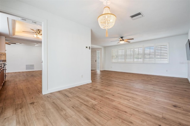 7092 S Shore Dr S, Saint Petersburg, FL 33707 - unfurnished living room featuring ceiling fan, a chandelier, light wood-style flooring, and baseboards