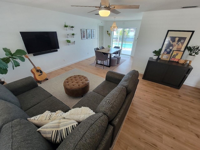7092 S Shore Dr S, Saint Petersburg, FL 33707 - living room with wood finished floors, a ceiling fan, and baseboards