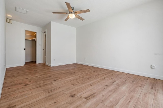 7092 S Shore Dr S, Saint Petersburg, FL 33707 - unfurnished bedroom featuring light wood-type flooring, baseboards, ceiling fan, a spacious closet, and a closet