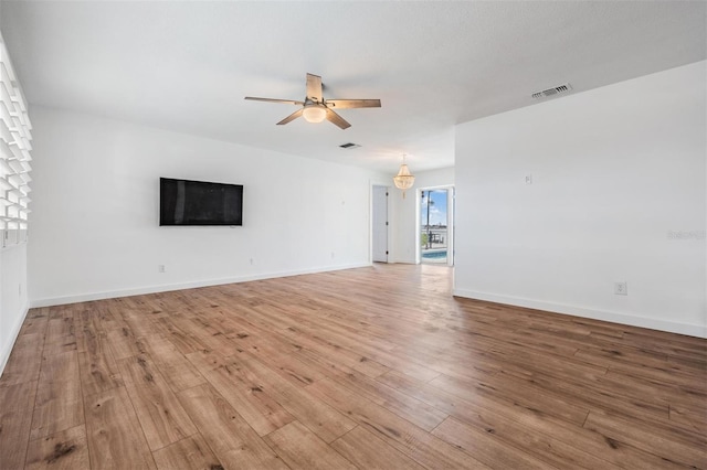 7092 S Shore Dr S, Saint Petersburg, FL 33707 - unfurnished living room with a ceiling fan, light wood-style flooring, and baseboards