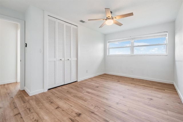 7092 S Shore Dr S, Saint Petersburg, FL 33707 - unfurnished bedroom with a closet, light wood finished floors, baseboards, and ceiling fan